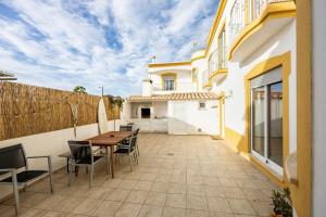 um pátio com uma mesa e cadeiras e um edifício em Local Guesthouse em Sagres