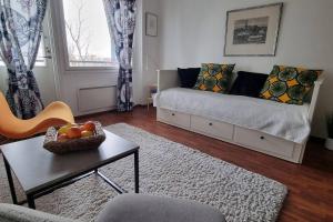 Cozy studio in Tampere for 2 with own Sauna,balcony and a free parking في تامبير: غرفة معيشة مع أريكة وطاولة