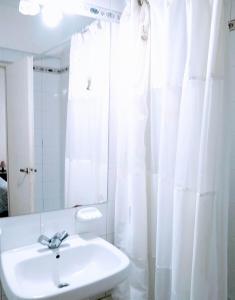 ein weißes Badezimmer mit einem Waschbecken und einem Spiegel in der Unterkunft Recoleta Loft con Terrazas in Buenos Aires