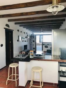 cocina con 2 taburetes y encimera en Coqueto apartamento en El Cuchillo, en Tinajo