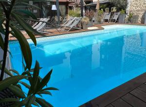 una piscina con agua azul, sillas y una planta en Le Trophée By M Hôtel Spa, en Deauville