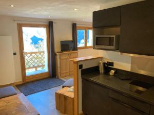 eine Küche mit einer Arbeitsplatte und einer Mikrowelle in der Unterkunft Chalet du Bersend in Beaufort + 20 Fotos