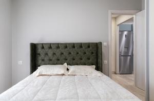 a bedroom with a large bed and a refrigerator at Garden Apartment in Amarynthos I in Amarynthos