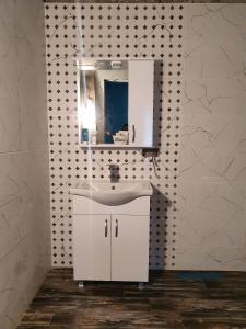 a bathroom with a white sink and a mirror at Racha - ABA in Ambrolauri