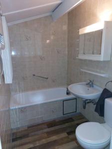een badkamer met een bad, een wastafel en een toilet bij Holiday home close to Plopsaland and the beach Duinendale 138 in De Panne