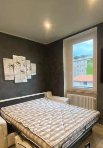 Schlafzimmer mit einem Bett und einem Fenster in der Unterkunft Marilyn Apartment in Como