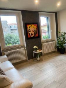 a living room with a couch and two windows at Marilyn Apartment in Como