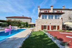 a swimming pool in front of a house with a pink flamingo at San Niccolo in Vilanija