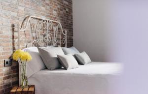 um quarto com uma cama branca e uma parede de tijolos em Casa Serendipia em La Asomada