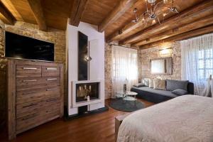 a bedroom with a couch and a tv and a fireplace at San Niccolo in Vilanija