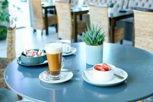 - une table avec une tasse de bière et un bol de fraises dans l'établissement Ocean Breeze Hotel, à Strand