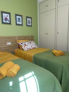 2 Betten in einem Zimmer mit grünen Wänden in der Unterkunft Picasso in Rincón de la Victoria
