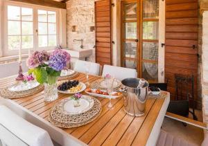 a dining room table with plates of food and flowers at San Niccolo in Vilanija