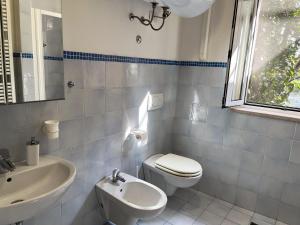 a bathroom with a white toilet and a sink at Appartements dans agréable maison de ville centre historique de Rimini in Rimini