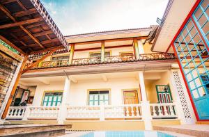 a house with a balcony and a swimming pool at Dream House Lodge in Sukhothai