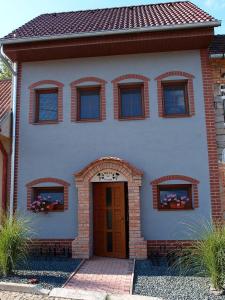 uma casa branca com uma porta castanha e janelas em Sklípek na Větřáku em Cejkovice