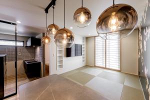a kitchen with copper pendant lights and tile floors at 【Oyado道】貸切露天風呂付！別荘感覚で新築一軒家まるごと貸し切り１日１組限定！ハウステンボス近く in Hayaki