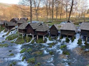 um grupo de cabanas de madeira sobre um rio em Apartman D&D em Jajce