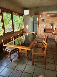 uma sala de jantar com uma mesa de vidro e cadeiras em Green Toque-Toque em São Sebastião