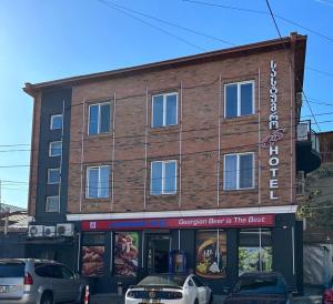 a brick building with cars parked in front of it at GS Hotel in Tbilisi City