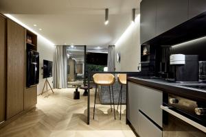 a kitchen with a counter and chairs in a room at Icon Suite in Athens