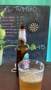 a bottle of beer sitting next to a glass at EL TUMBO in Rivas