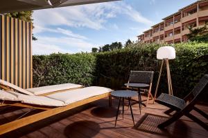 a patio with a bench and chairs on a deck at Icon Suite in Athens