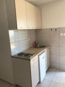 eine kleine Küche mit weißen Schränken und einem Waschbecken in der Unterkunft Zo-Mi Apartments in Tivat