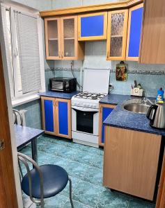 a small kitchen with a sink and a stove at Однокомнатная квартира Авангард 2 in Atyrau