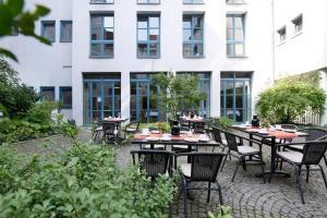 a patio with tables and chairs in front of a building at Hanns-Lilje-Haus in Hannover
