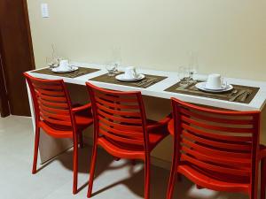 a table with two chairs and a table with wine glasses at FLAT BADEJO in Japaratinga
