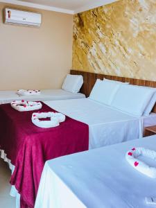 um quarto com duas camas com lençóis vermelhos e brancos em FLAT BADEJO em Japaratinga