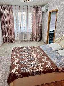 a bedroom with a bed and a mirror and curtains at Однокомнатная квартира Авангард 2 in Atyrau