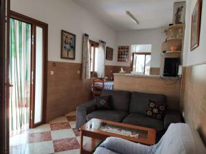 a living room with a couch and a table at La casita de Poniente. Enjoy it! in Huelva