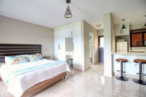 a bedroom with a large bed and a kitchen at San Lameer Villa 2004 by Top Destinations Rentals in Southbroom