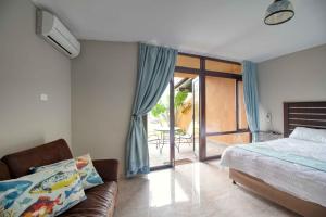 a bedroom with a bed and a couch and a balcony at San Lameer Villa 2004 by Top Destinations Rentals in Southbroom