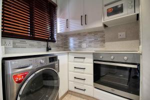a kitchen with a dishwasher and a washer and dryer at San Lameer Villa 2004 by Top Destinations Rentals in Southbroom