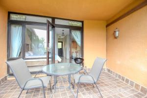 a glass table and chairs on a patio at San Lameer Villa 2004 by Top Destinations Rentals in Southbroom