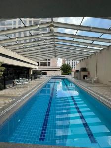 - une grande piscine avec des carreaux bleus dans un bâtiment dans l'établissement Hotel Aeroporto Congonhas UH-504, à São Paulo
