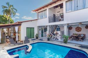a villa with a swimming pool in front of a house at SPA&Hospedagem Giovannini Massagem inclusa in Pirenópolis