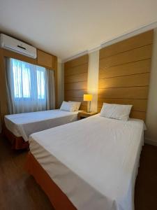 ein Hotelzimmer mit 2 Betten und einem Fenster in der Unterkunft Hotel Aeroporto Congonhas UH-504 in São Paulo