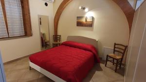 a bedroom with a red bed in a room at Nato Contadino in Capalbio