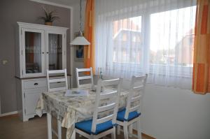 a dining room with a table and chairs and a window at Ort Lemkenhafen Bolle in Fehmarn