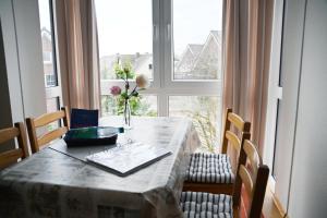 a table with a vase of flowers on it with a window at Ort Lemkenhafen Melchinger in Fehmarn