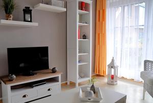 a living room with a television on a white entertainment center at Ort Lemkenhafen Bolle in Fehmarn