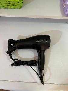a black hair dryer sitting on a shelf at Casa Armonia in Nea Kallikrateia