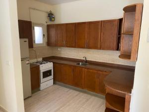 a kitchen with wooden cabinets and a sink and a stove at Bahga Palace 2 Residential Apartments in Hurghada