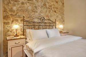 a bedroom with a bed and two lamps on tables at Villa Arhontiko In Arhanes in Archanes