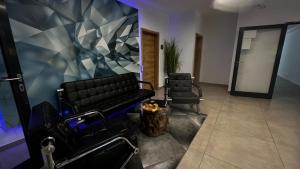 a waiting room with two barber chairs and a wall at VitaLounge Sports & Spa Hotel in Gelsenkirchen