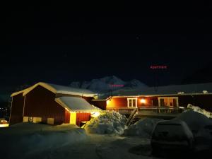 a house is covered in snow at night at Rystad midnight sun and nature in Rystad